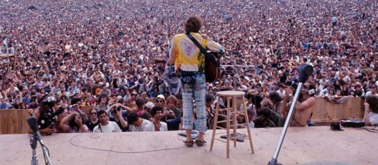 Which famous 1969 music festival on a cozy New York farm became a beautiful symbol of peace, love, and music?